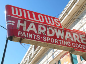 Old fashioned red storefront sign reading Willows Hardware Paints Sporting Goods