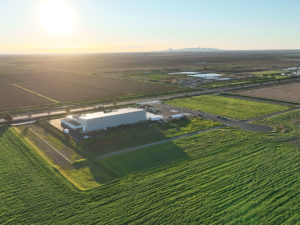 Long distance aerial shot of Basin Street Industrial Park with surrounding farmland